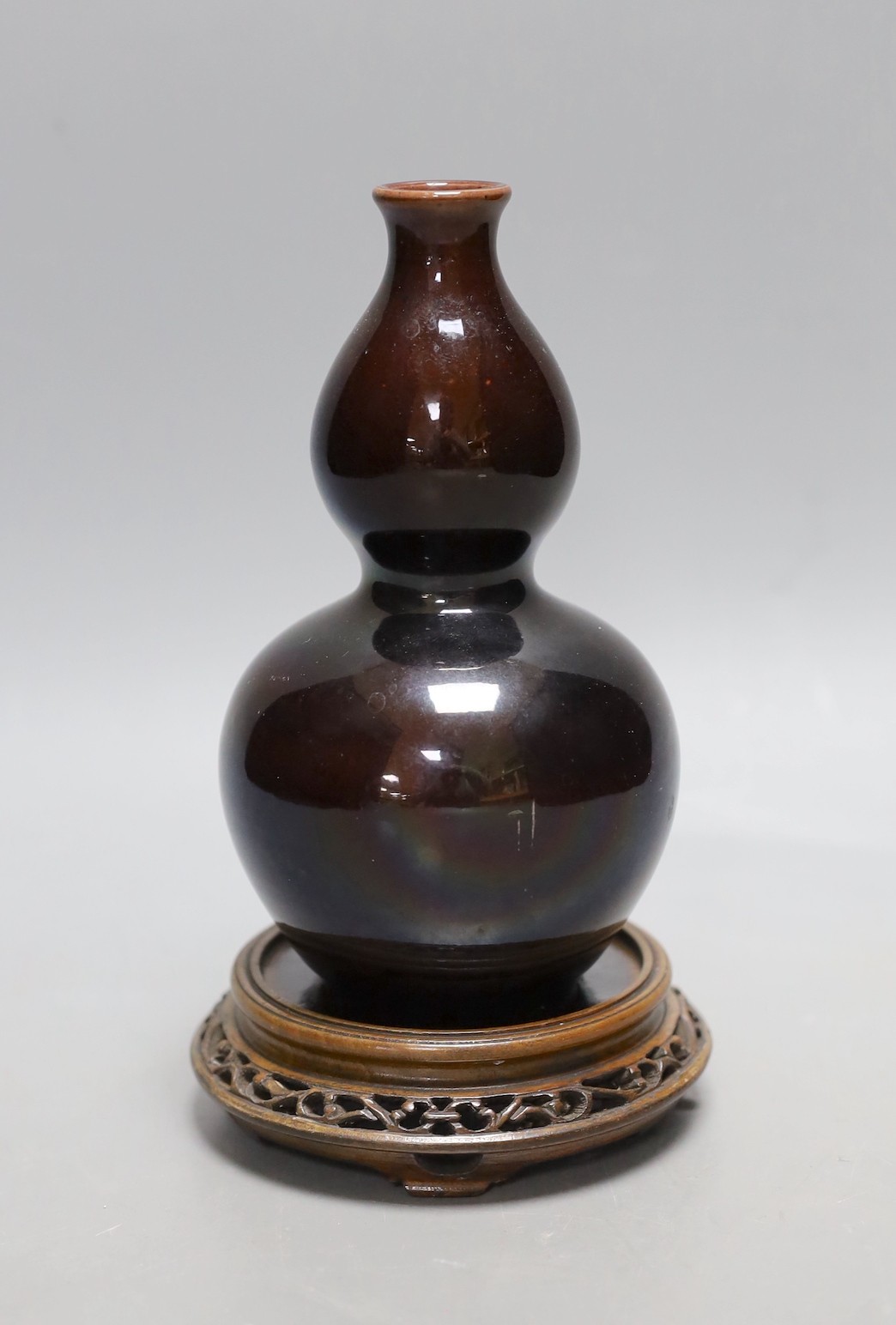 A Chinese brown monochrome double gourd vase (on stand). 19cm tall